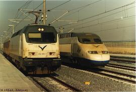 Locomotora eléctrica 252 - 002 - 1 de RENFE, remolcando un coche de viajeros, junto a una composi...