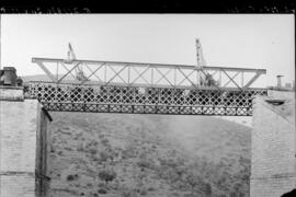 Grúas trabajando en la sustitución de tramos metálicos en el puente sobre el río Azuer de la líne...