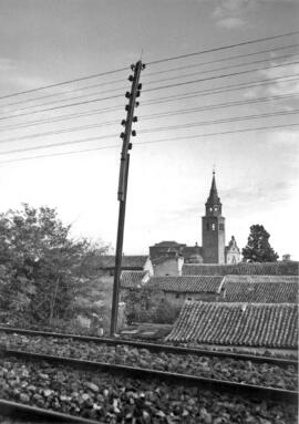 Poste de tendido de comunicaciones, al fondo iglesia