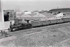 Composición de mercancías, formado por vagones cerrados, y remolcada por locomotora de vapor de l...