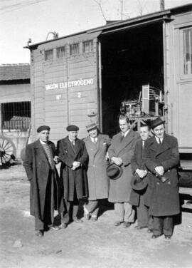 Grupo de personas posando delante del vagón electrógeno nº 2 del Servicio Eléctrico de RENFE en A...