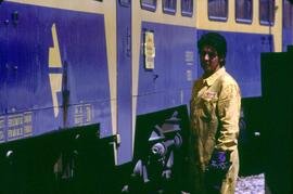 Operario junto a un automotor diésel de la serie 593 de RENFE, también conocido como "camell...