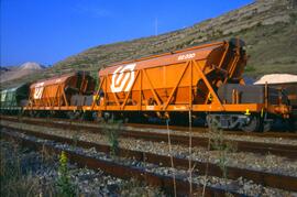 Perspectiva parcial de una composición de tren de mercancías con vagones tolva de los Ferrocarril...