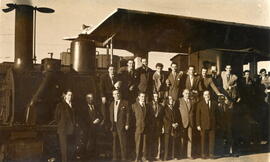 Asistentes al homenaje de jubilación de Antonio Carrión delante de una locomotora de vapor de rod...