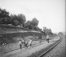 Personal ferroviario y niños caminando junto a las vías, en las proximidades de la estación de Ro...