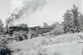 Composición de viajeros del Ferrocarril de Langreo, remolcada por locomotora de vapor, saliendo d...