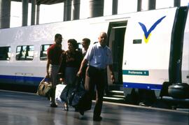 Viajeros junto a un tren AVE serie 100 en la estación Puerta de Atocha