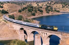 Tren de viajeros a su paso por el puente sobre el arroyo Villoluengo, en la línea de Madrid a Val...