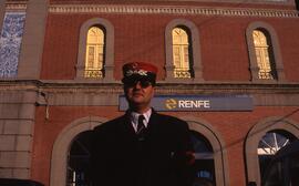 Jefe de estación de RENFE, posando uniformado frente a una estación sin identificar