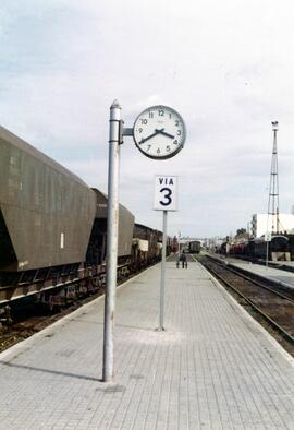 Reloj tipo "sandwich" situado en el andén intermedio de una estación sin identificar