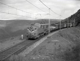 Composición de mercancías remolcada por locomotora eléctrica de la serie 7700 de RENFE, luego ren...