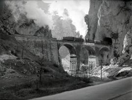 Composición de viajeros remolcada por locomotora de vapor atravesando el viaducto de Pancorbo o d...