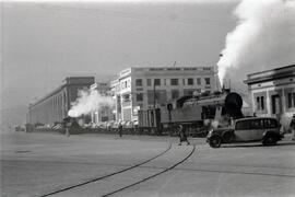 Composiciones de mercancías circulando por Barcelona, remolcadas por una locomotora de vapor  (se...
