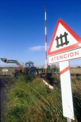 Señal de paso a nivel con barreras y tractor agrícola en Alboraya, línea Valencia - Barcelona