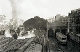 Composición de mercancías remolcada por locomotora de vapor saliendo de la estación de Valencia -...