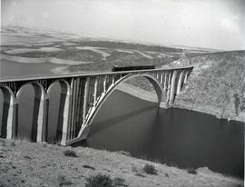 Composición de viajeros remolcada por locomotora de vapor atravesando el viaducto de Martín Gil s...