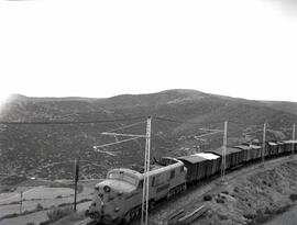Composición de mercancías remolcada por locomotora eléctrica de la serie 7700 de RENFE, luego ren...