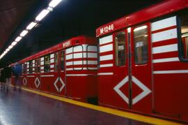 Perspectiva de una unidad del Metro de Madrid de la serie 1000 detenida en unos andenes sin ident...