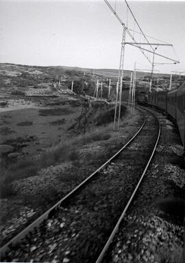 Composición de viajeros remolcada por locomotora eléctrica en un lugar sin identificar de la líne...