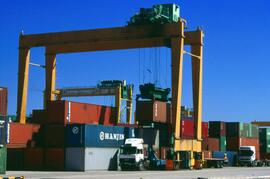 Proceso de carga de contenedores mediante grúas pórtico o puentes grúa en el puerto de Valencia