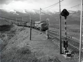 Composición de mercancías remolcada por locomotora eléctrica de la serie 7700 de RENFE, luego ren...