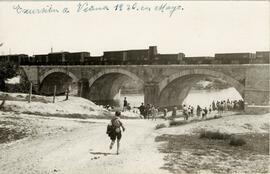 Tren de mercancías con vagones y furgones de la línea de Madrid a Irún pasando por un puente de C...