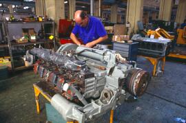 Operario trabajando con un motor diésel en un taller