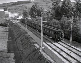 Composición de viajeros formada por coches metálicos y remolcada por una locomotora eléctrica sin...