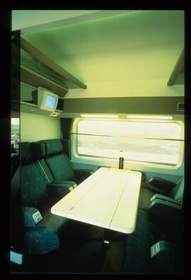Interior de un departamento de coche de viajeros AVE con mesa central