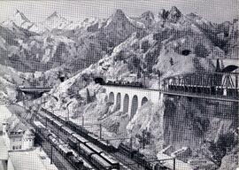Fotografía de maquetas de trenes eléctricos circulando por las vías, atravesando un puente metáli...