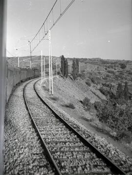 Composición de viajeros remolcada por locomotora eléctrica en un lugar sin identificar de la líne...