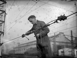 Personal ferroviario reparando el cable tensor de la instalación eléctrica de la catenaria en la ...