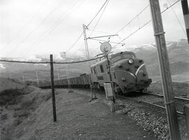 Composición de mercancías remolcada por locomotora eléctrica de la serie 7700 de RENFE, luego ren...