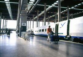 Viajeros junto a un tren AVE serie 100 en la estación Puerta de Atocha