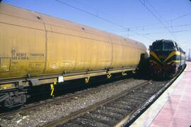 Vagón tolva y locomotora diésel - eléctrica de la serie 333 de RENFE en la estación de Alcázar de...