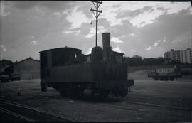 Locomotora de vapor, posiblemente 0-3-0 T, aparcada en la zona de muelles de una estación sin ide...